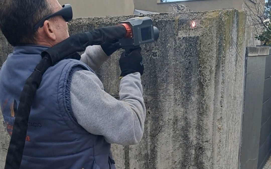 Operario aplicando limpieza láser sobre hormigón